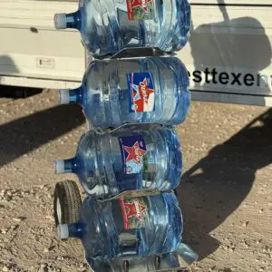 A stack of water bottles on the ground.